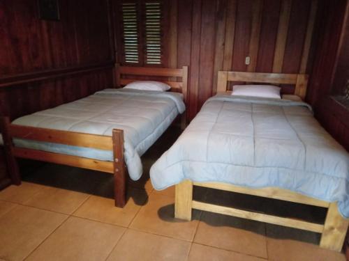 图里亚尔瓦Pochotel的木墙客房的两张床