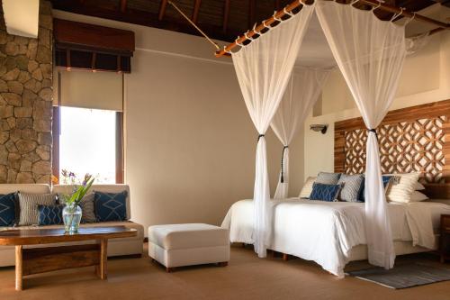 RecadoCasa Kundavi Beach Front Paradise的一间卧室配有两张床和一张天蓬床。