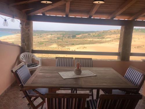 托雷戴科尔萨里La Villa dell Artista con vista mare e dune - IUN Q7440的一张木桌和椅子,享有沙漠美景