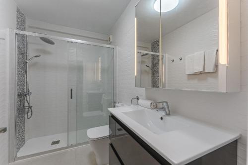 洛斯克里斯蒂亚诺斯LosCristianos Front Line of Ocean WiFi的白色的浴室设有水槽和淋浴。