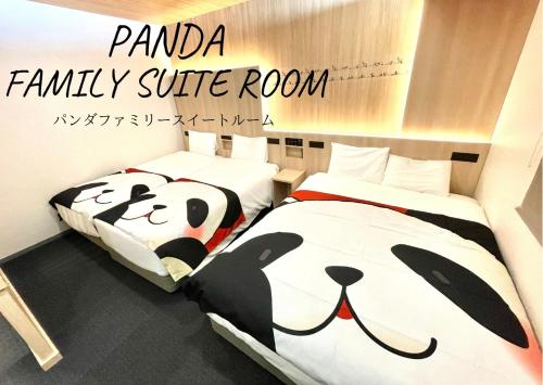 东京Henn na Hotel Tokyo Asakusa Tawaramachi的熊猫家庭套房内的两张床