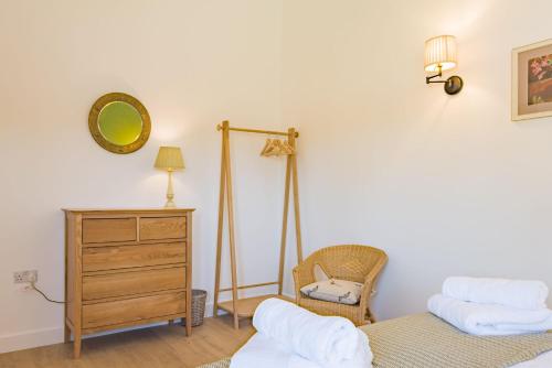 StalisfieldThe Parlour by Bloom Stays的一间卧室配有两张床、一个梳妆台和镜子