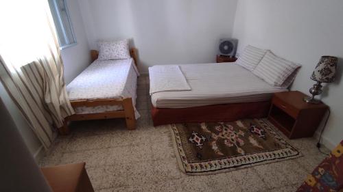 ChebbaCharmant logement avec jardin en permaculture的一间小卧室,配有两张床和地毯