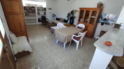 ChebbaCharmant logement avec jardin en permaculture的客厅配有桌子和白色椅子
