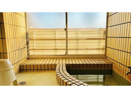 静冈Kagetsu Ryokan - Vacation STAY 04023v的客房设有窗户和带浴缸的浴室