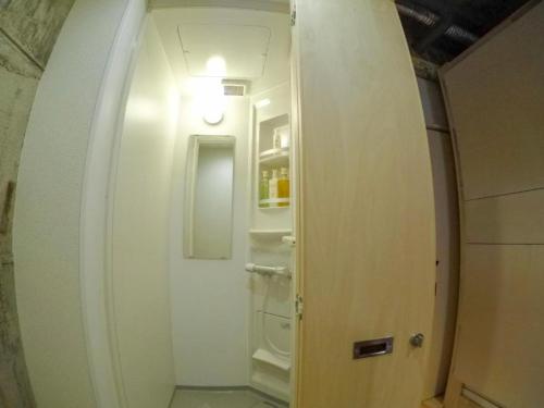 高松Konyamachi Guest House Kuku - Vacation STAY 72725v的走廊通往带白色门的浴室