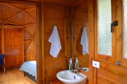 瓜塔维塔Arrecife Glamping的一间带水槽的浴室和一张位于客房内的床