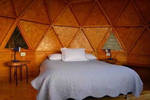 瓜塔维塔Arrecife Glamping的木制客房内的一间卧室,配有一张床