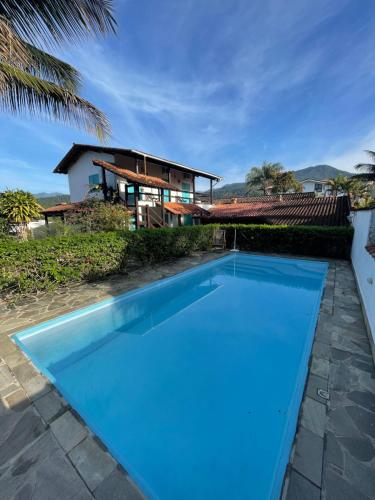 帕拉蒂Villa Tiê Paraty的一座大蓝色游泳池,位于房子前