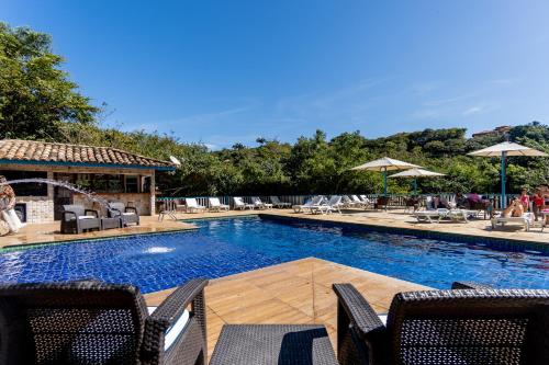布希奥斯Hotel Miratlantico Búzios的一个带椅子和遮阳伞的大型游泳池