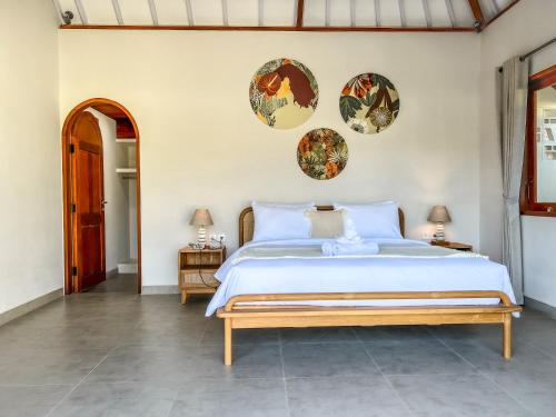 乌鲁瓦图Moana Villa & Suites Bingin的卧室配有一张大床,墙上有三个盘子