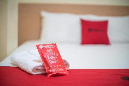 贝努阿亚尔RedDoorz Syariah near Taman Siring 2的睡床上的红色牙膏包