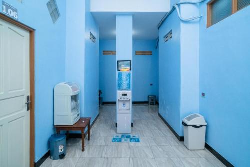 贝努阿亚尔RedDoorz Syariah near Taman Siring 2的一间蓝色的房间,里面装有机器