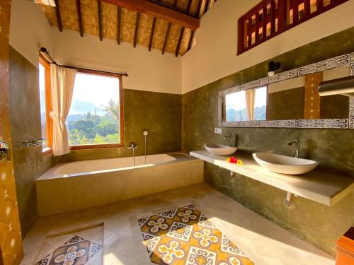 希德门库布塔尼酒店的一间带两个盥洗盆、浴缸和窗户的浴室