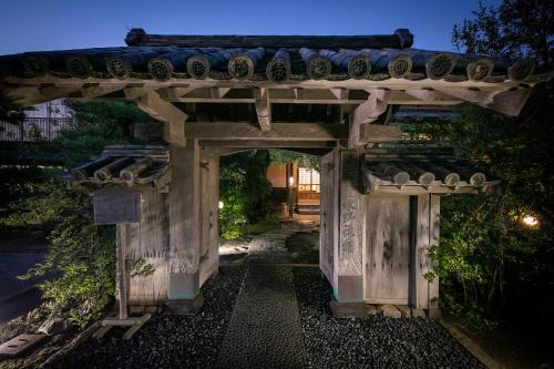 唐津美津浓旅馆 的通往带石拱门的花园的入口