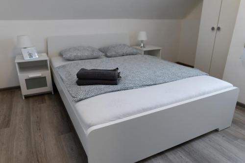 福纽德Olivér 22 Apartman的一张白色的床,上面装有黑袋