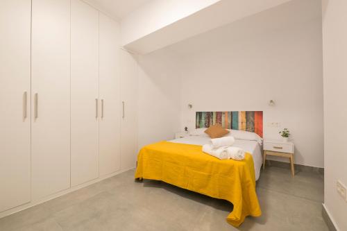 格拉纳达Apartamento Ribera del Genil Centro的白色卧室配有一张黄色毯子床