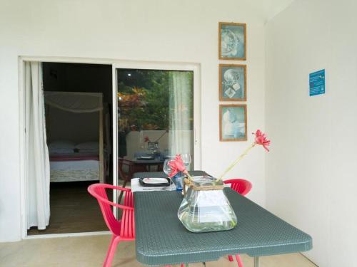 安塞罗亚莱Le Comfort (self catering)的一张桌子,上面有两把红色的椅子和花瓶