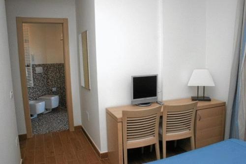 波尔图·埃尔科莱碧酒店的客房设有一张桌子、一台电视和一张床