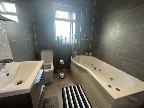 伦敦Deluxe Homestay near Tottenham Hotspur Stadium的带浴缸、卫生间和盥洗盆的浴室