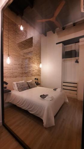 塞维利亚Carmona&House的一张大白色的床,位于带镜子的房间里