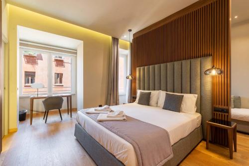 罗马ELICAL Exclusive Private Suites的一间卧室配有一张大床和一张带椅子的桌子