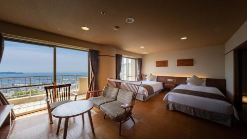 热海热海龟之井酒店(KAMENOI HOTEL ATAMI)的酒店客房设有两张床和一个阳台。