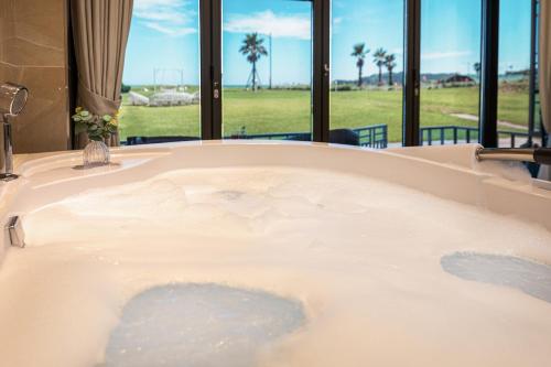 西归浦市日月度假酒店的享有田野景色的按摩浴缸