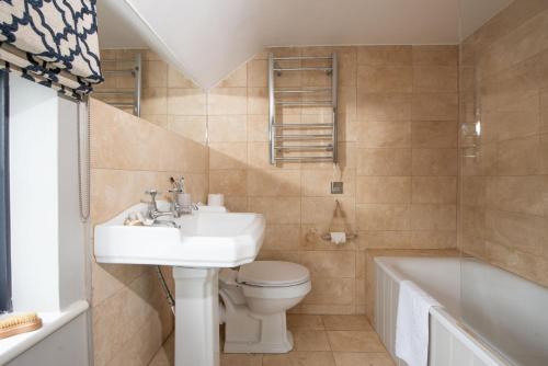 圣艾夫斯Spindrift, St Ives的浴室配有盥洗盆、卫生间和浴缸。