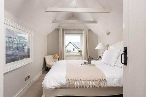 圣艾夫斯Spindrift, St Ives的白色的卧室设有床和窗户