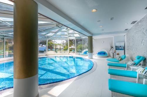 奥帕提亚阿玛迪利亚公园米勒尼酒店的一座带蓝色椅子的游泳池和一座游泳池