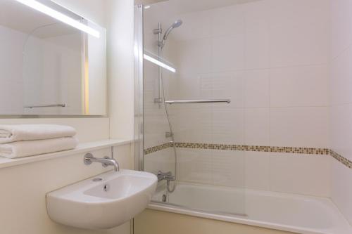 梅斯苔丝Kyriad Annecy Nord - Epagny的白色的浴室设有水槽和淋浴。