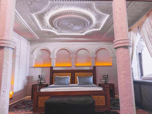格雷梅本地岩洞酒店的一间卧室设有一张带格子天花板的床。