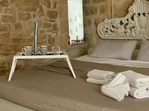巴列塔B&B Casa AMALIA的一间卧室配有一张带毛巾的桌子和一张床