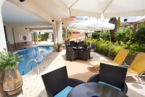 利迈纳里亚戈尔登公寓式酒店的一个带桌椅的户外庭院和一个游泳池
