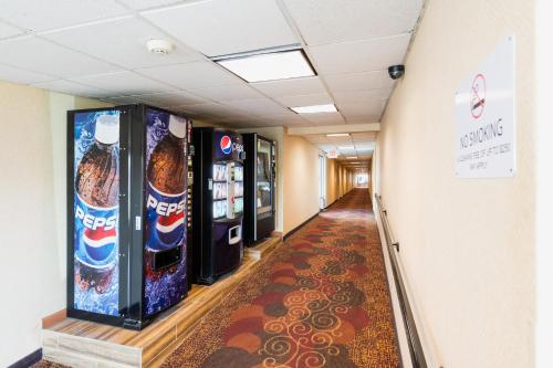 南普莱恩菲尔德花园行政酒店的走廊上设有自动售货机的走廊