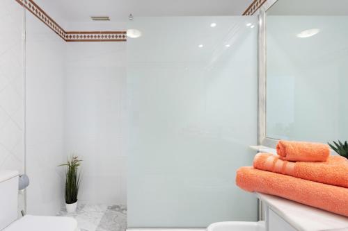 桑蒂亚戈德尔泰德Unique Buenavista的柜台上配有橙色毛巾的浴室