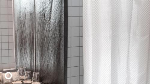 雷克雅未克Center Hotels Klopp的浴室配有淋浴帘和镜子