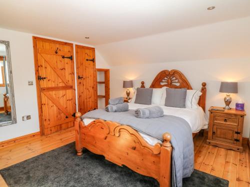比迪福德Rosies Barn的一间卧室配有一张木床和两个枕头