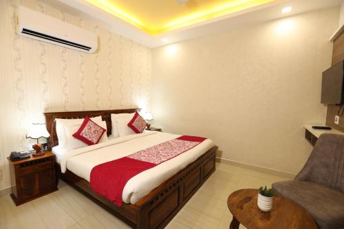 法里达巴德Hotel Lavit Couple Friendly near Faridabad Metro station的配有一张床和一把椅子的酒店客房