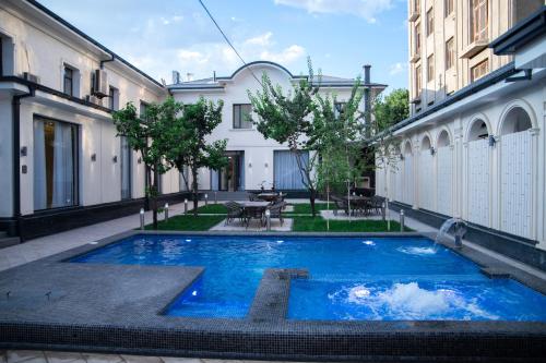 撒马尔罕Turon Lux Hotel的大楼中央的一个大型蓝色泳池
