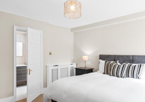 布里斯托Stunning 2 bedroom apartment in fantastic location的白色卧室配有白色的床和灯