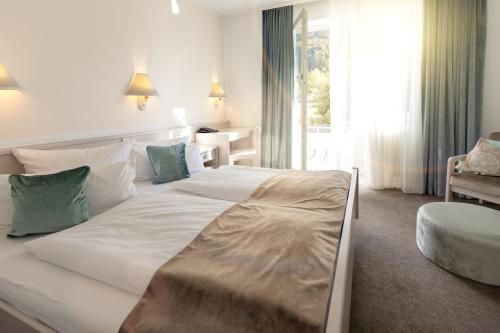 Wurmlingen特拉贝酒店的卧室配有一张白色大床和一把椅子