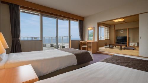 热海热海龟之井酒店别馆(Kamenoi Hotel Atami Annex)的酒店客房设有两张床和一个阳台。