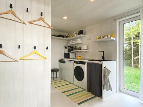 TagakülaMaasikmäe- unustamatu puhkus looduse vaikuses的一间厨房,在房间内配有洗衣机和烘干机
