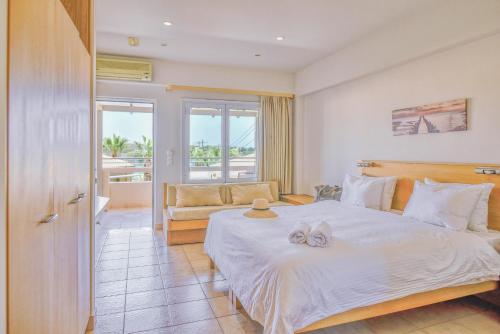 阿齐亚佩拉加Anatoli Apartments的卧室配有一张白色的大床和一张沙发。