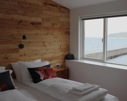 东博尔加峡湾Blabjorg Resort的一间卧室设有木墙和一张带窗户的床
