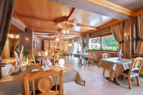 沙泰勒Hôtel Macchi Restaurant & Spa的餐厅设有木制天花板和桌椅