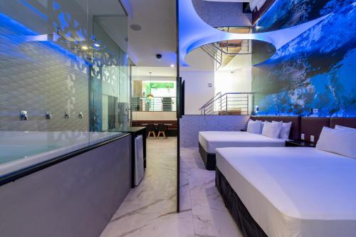 马瑙斯Drops Motel Manaus的酒店客房设有两张床和浴缸。