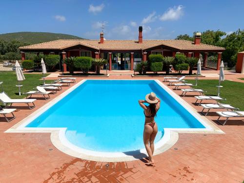 圣塔·马里亚·迪·帕尔玛Villa Barbarina Nature Resort的站在游泳池旁的比基尼的女人